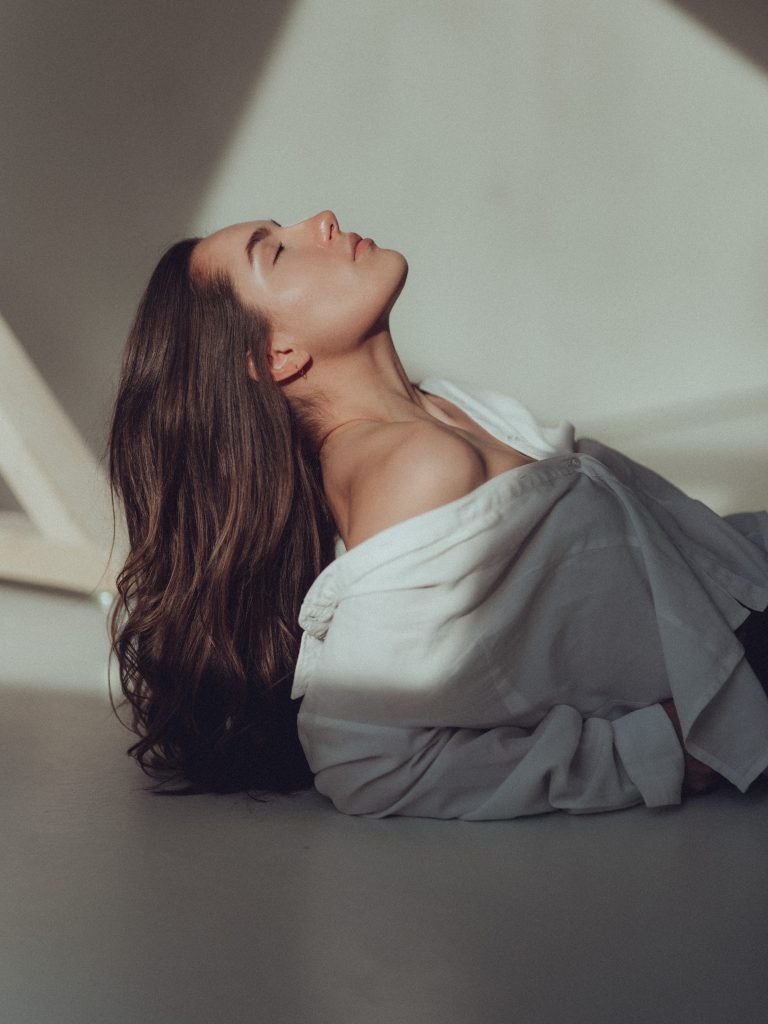 Foto aus dem studio liz. Eine Frau liegt auf dem Boden. Ihr Blick geht Richtung Decke.