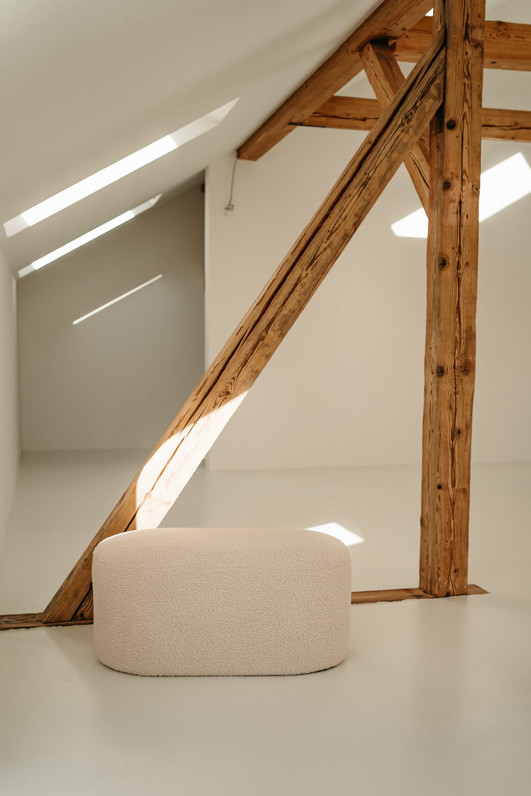 Foto von einem Holzbalken im studio liz. Vor dem Balken steht ein Hocker.