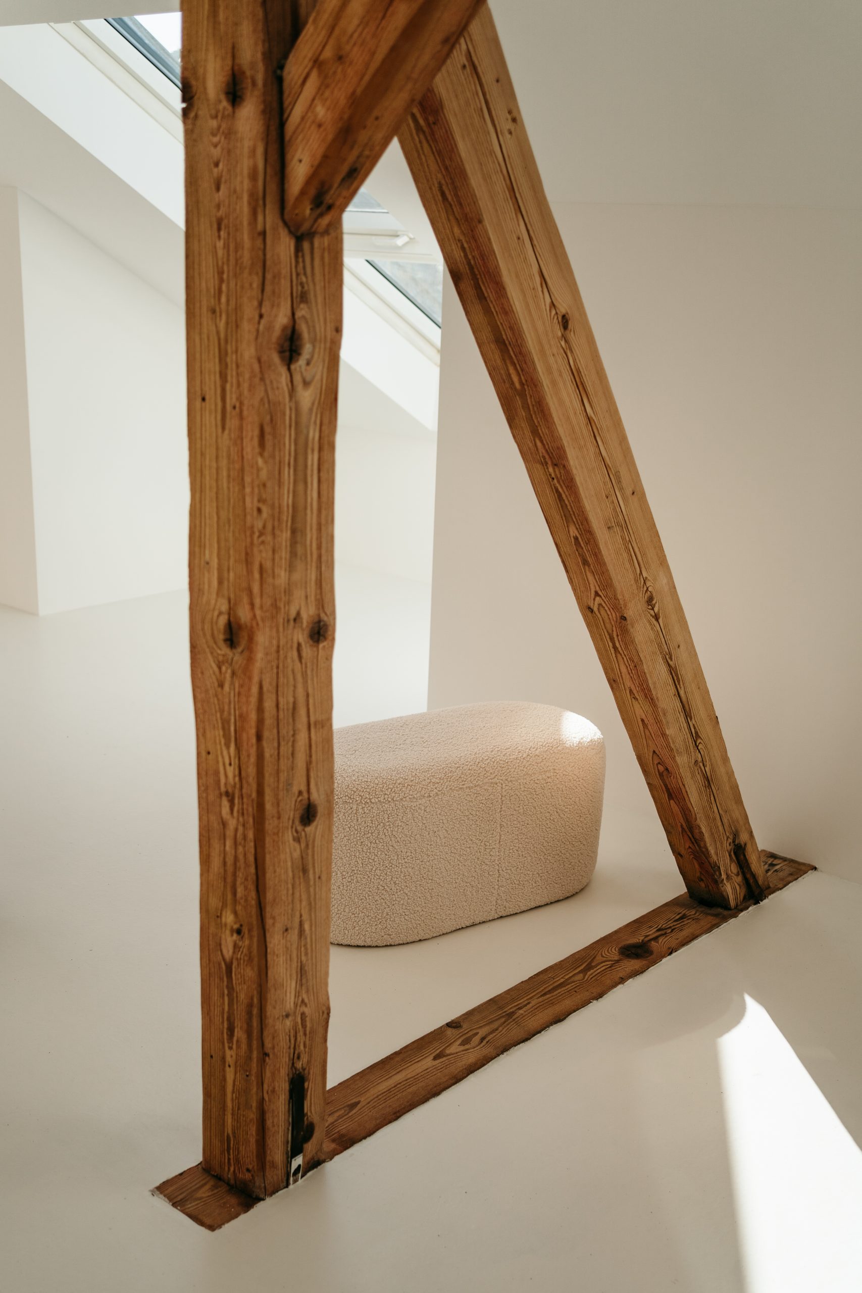 Foto von einem Holzbalken im studio liz. Hinter dem Balken steht ein Hocker.